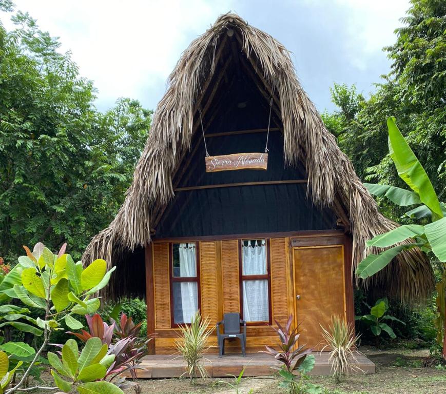 uma pequena casa com telhado de palha em Ecohab - Sierra Nevada em Santa Marta