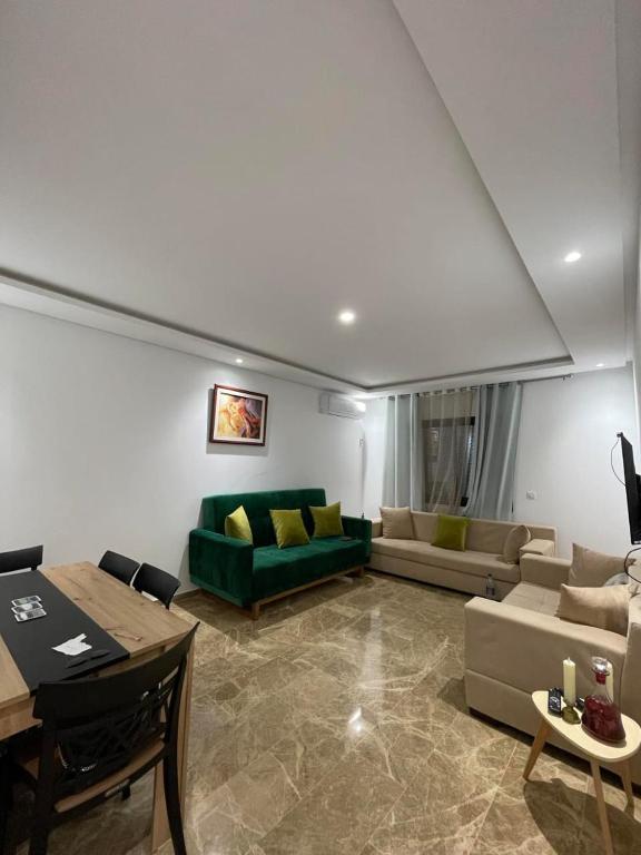 a living room with a green couch and a table at Lux appartment khezama sousse in Sousse