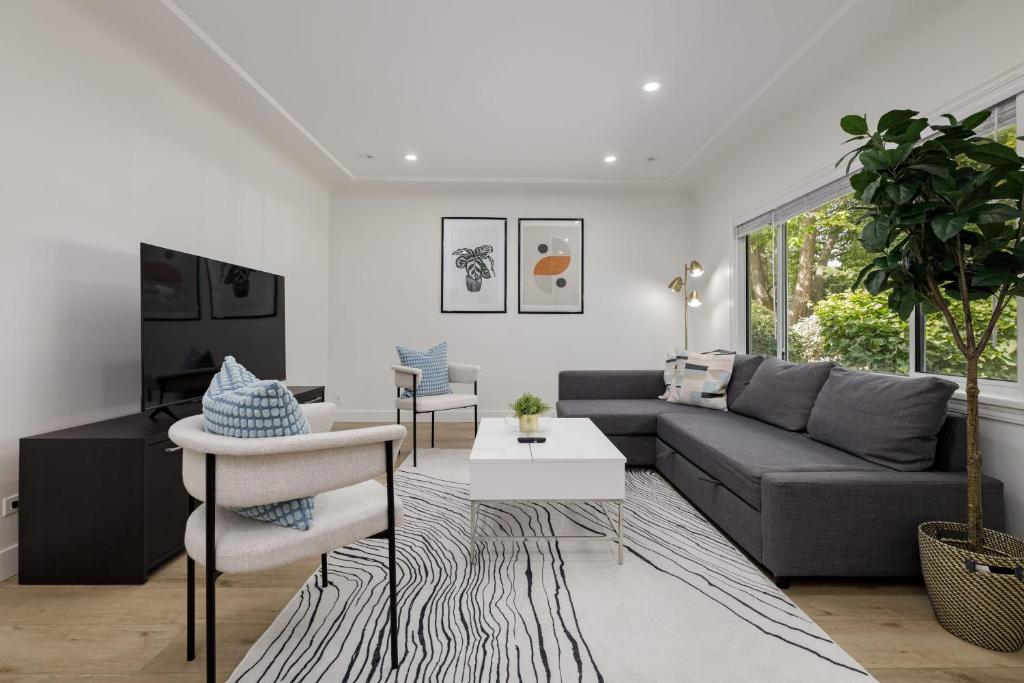 ein Wohnzimmer mit einem Sofa und einem Tisch in der Unterkunft Spacious Fully Furnished 2-BR Suite in Vancouver