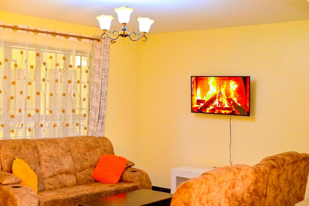 a living room with a couch and a fireplace at Haven Luxury Homes in Kitengela 