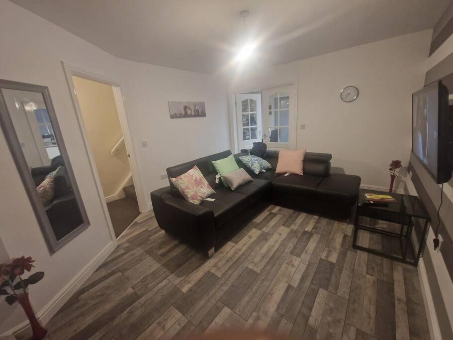 a living room with a black couch and a television at Getaway Haven 