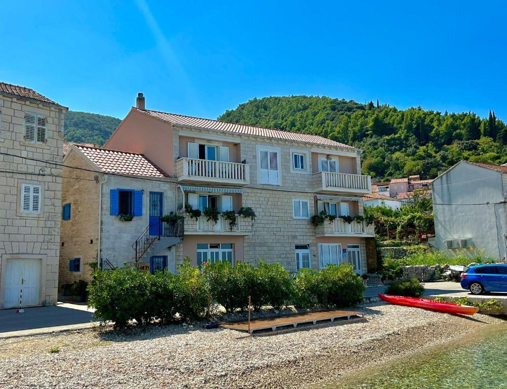 a large house with a car parked in front of it at Apartments Korta in Račišće