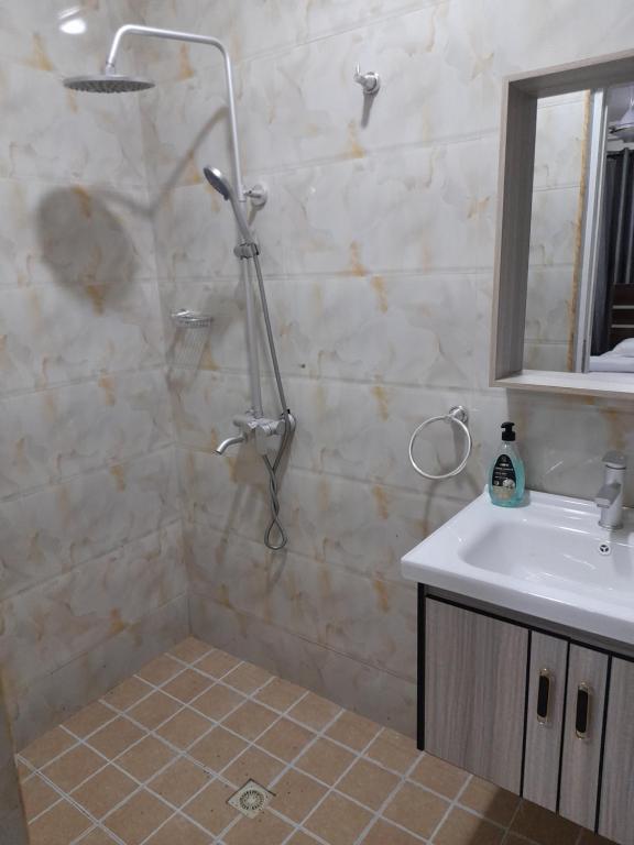 a bathroom with a shower and a sink at Atom Height Apartments in Tema