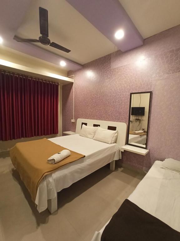 1 Schlafzimmer mit 2 Betten und einem Spiegel in der Unterkunft Malwade Motel in Pune