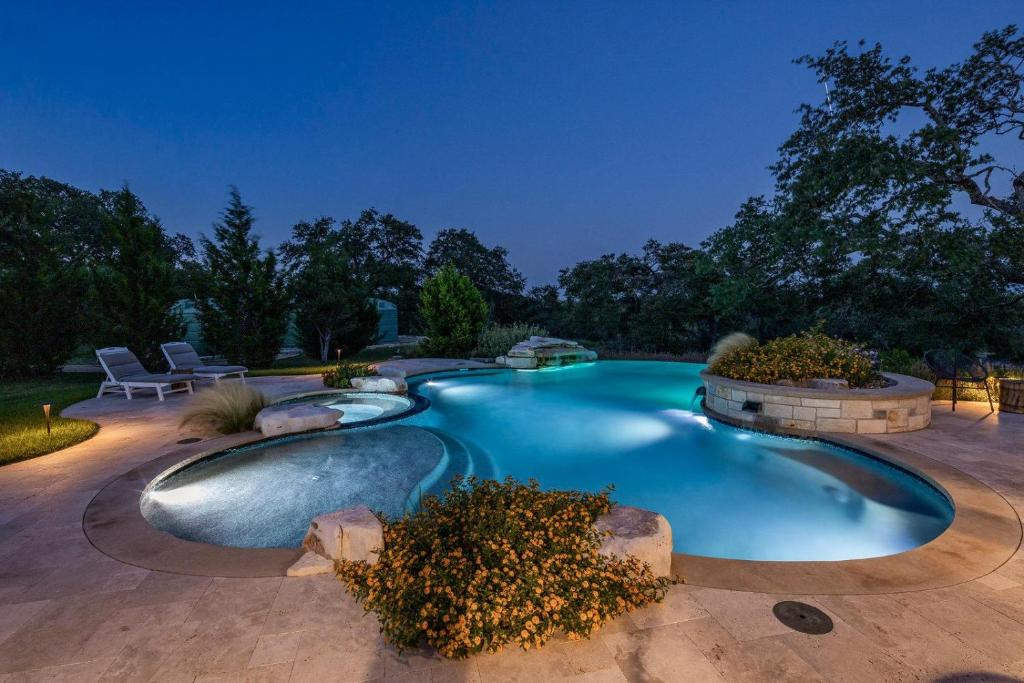 a swimming pool in a backyard at night at Driftwood Casitas - Moonlight Casita in Wimberley