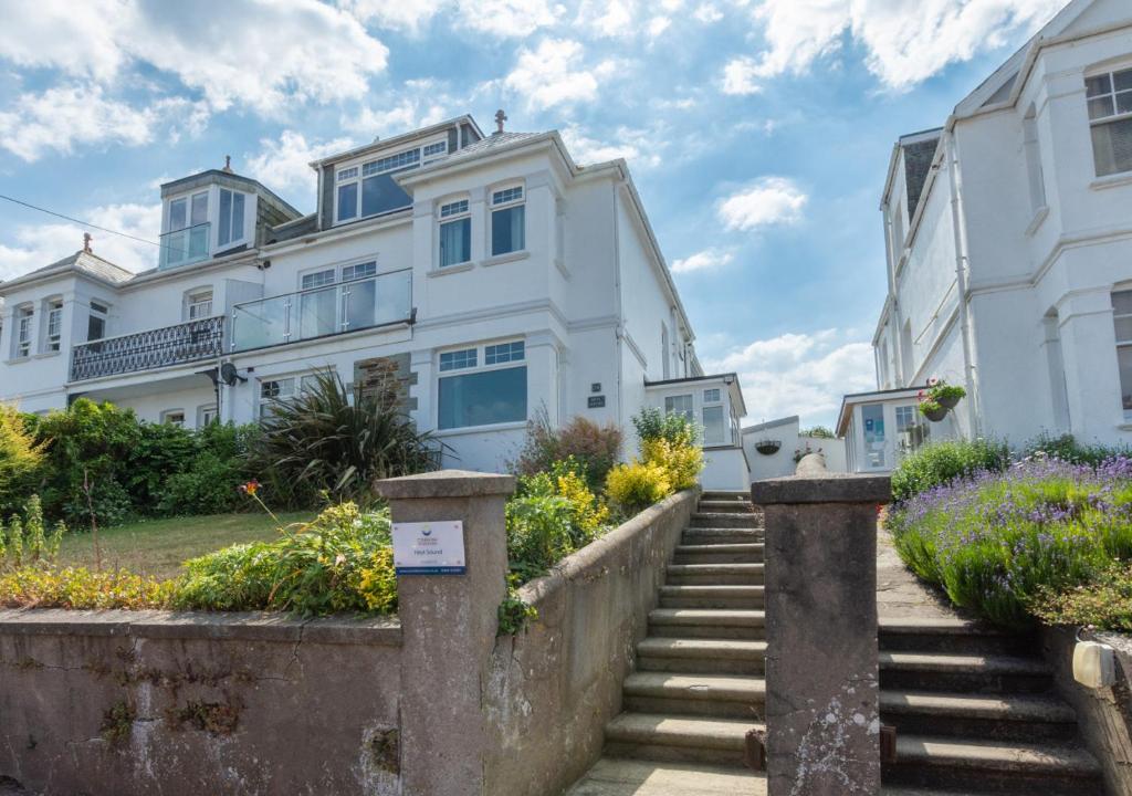 uma grande casa branca com escadas em frente em Heyl Sound em Padstow