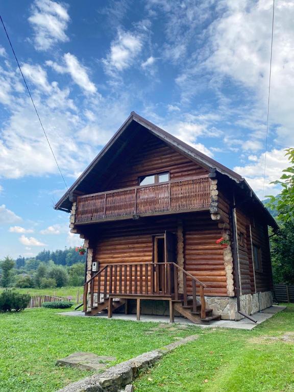 a log cabin with a porch and a deck at Садиба Краєвських in Krapivnik