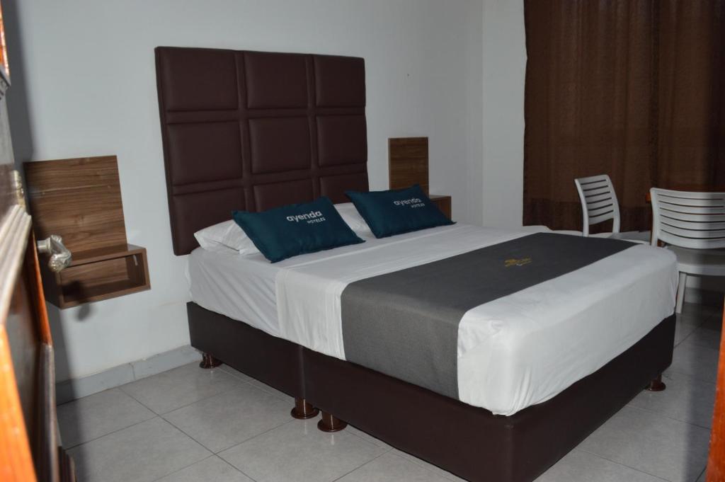 1 dormitorio con 1 cama grande con almohadas azules en Ayenda Casa Aika Sucre en Lima