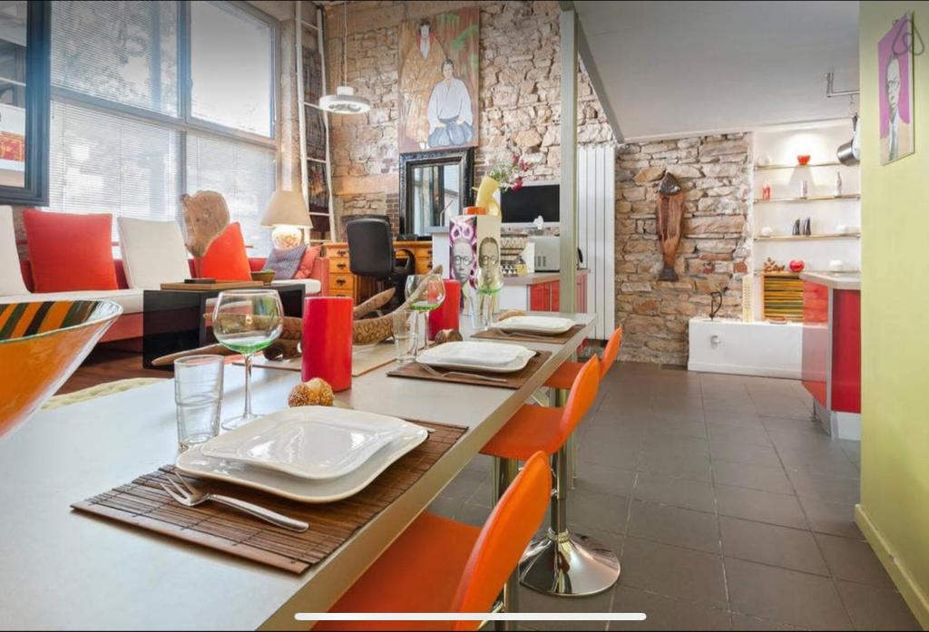 Hotel Loft sur saône, a dining room with a long table and orange chairs at Loft sur saône in Lyon