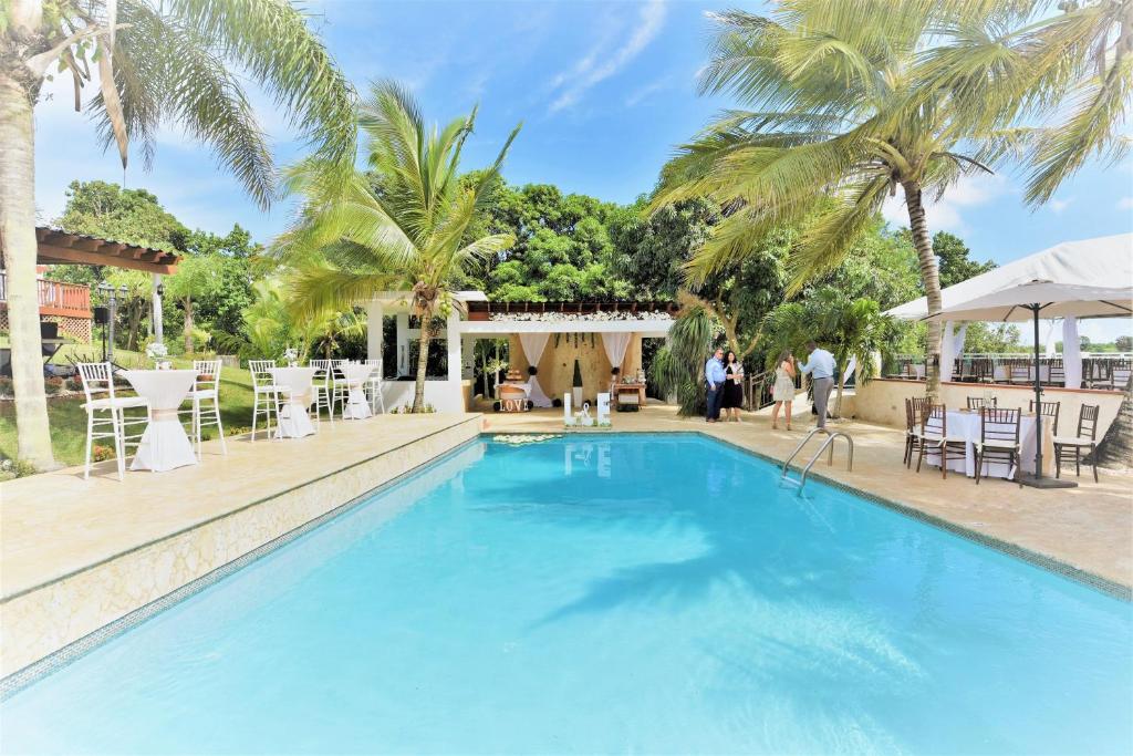 a swimming pool with palm trees and people walking around it at Luxury Villa Bonita Sleep 50 + in Isabela