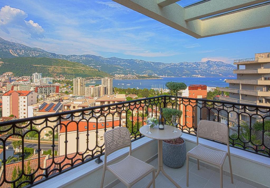 balcón con mesa, sillas y vistas en Aparthotel Villa Aria, en Budva