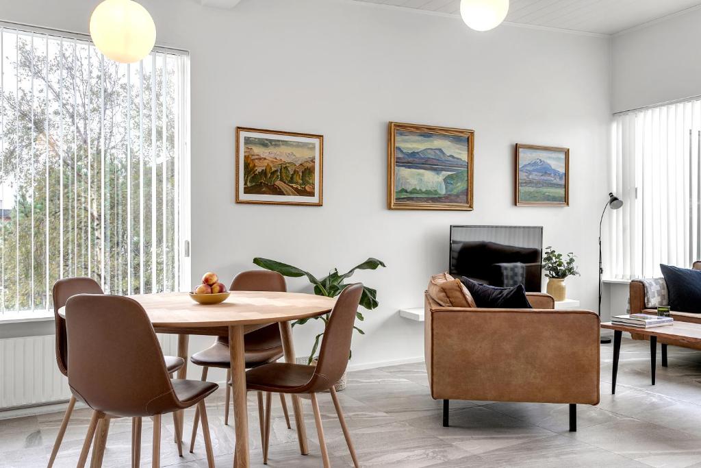 a living room with a dining room table and chairs at Nes Residence in Reykjavík