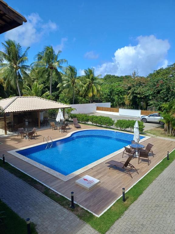 una piscina con sillas y sombrillas en un complejo en LAZER EM GUARAJUBA en Guarajuba