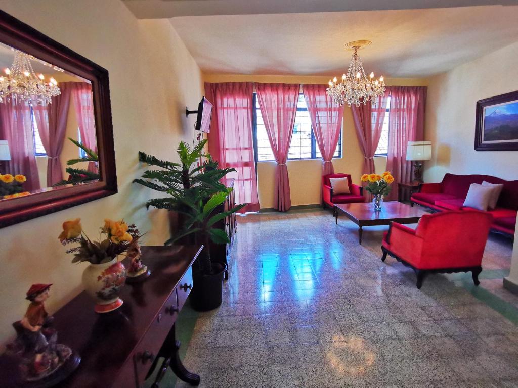 a living room with a red couch and a red chair at Departamento vintage in Papantla de Olarte