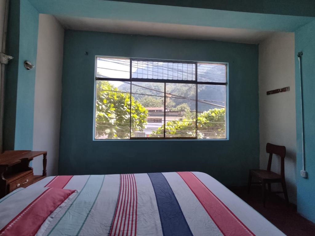 a bedroom with a bed and a large window at Garrison Alojamiento , selva y Turismo y Comida in Tingo María