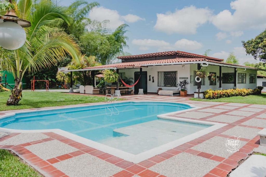 a swimming pool in front of a house at Hotel Vivero Arte Vivo I Quindío I Eje Cafetero in La Tebaida