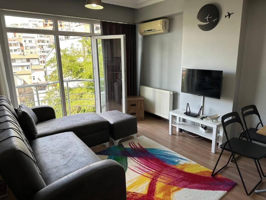 een woonkamer met een bank en een televisie bij 1Brr in Taksim in Istanbul