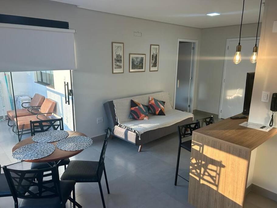 een woonkamer met een bank en een tafel en stoelen bij Apartamento aconchegante no centro de São Lourenço in São Lourenço