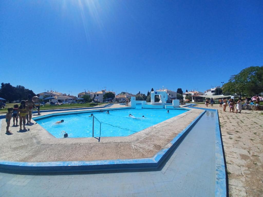 een groot zwembad met mensen erin bij Pedras D` EL Rei Village in Tavira