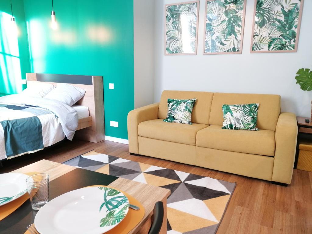 una sala de estar con un sofá y una cama en WelkHome Inn Best Suites - Spa, en Troyes