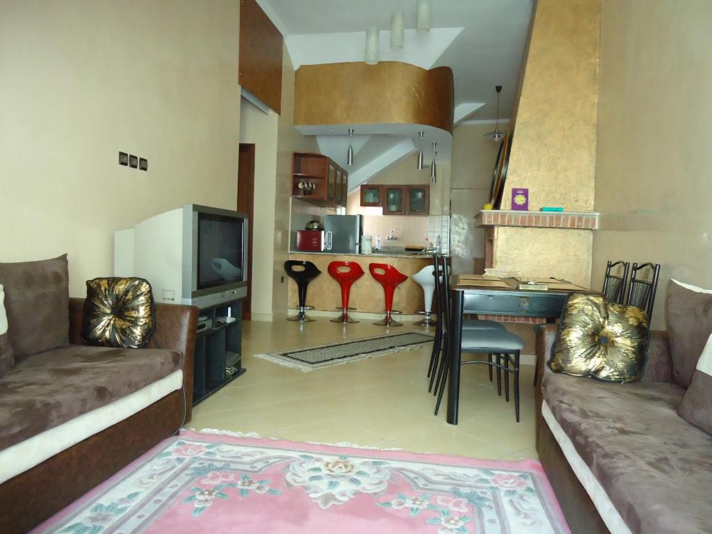 sala de estar con sofá, mesa y cocina en Bel Appartement à Ifrane en Ifrane