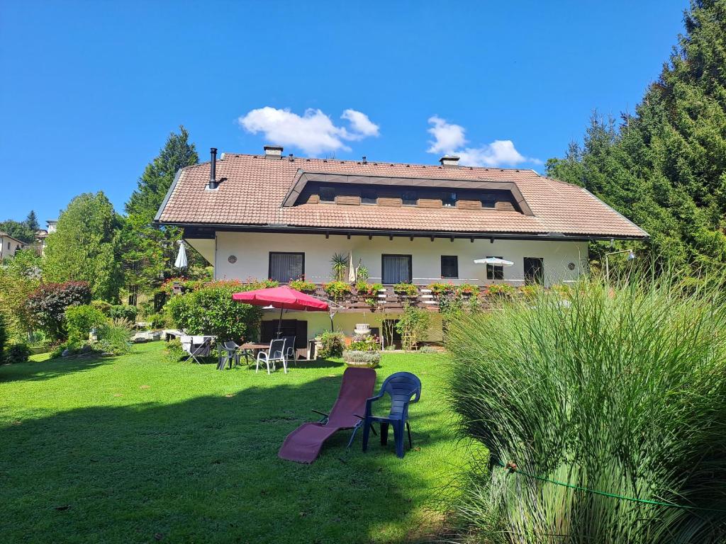 une grande maison avec une cour dotée d'un toboggan dans l'établissement Appartements Kubisko, à Keutschach am See