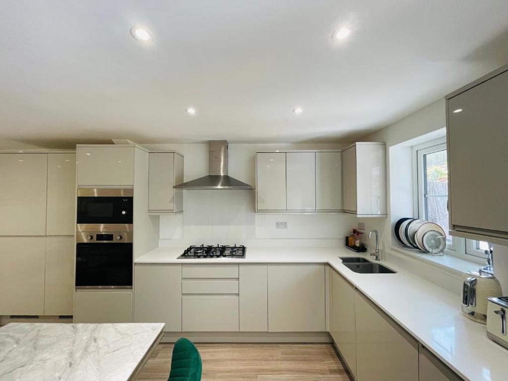 a kitchen with white cabinets and a stove top oven at Riverside En suite Double Room E14 in London