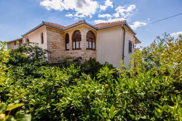 a house on top of a hill with trees at Apartments Ruzarija in Trogir