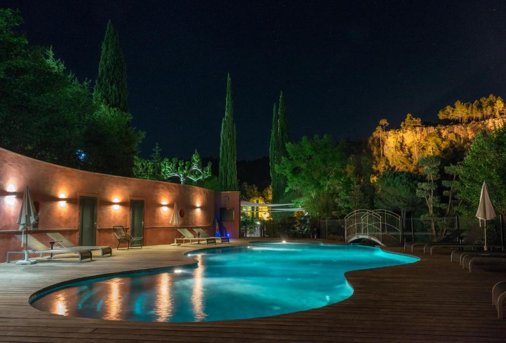 a swimming pool in a yard at night at Hostellerie Les Gorges De Pennafort in Callas