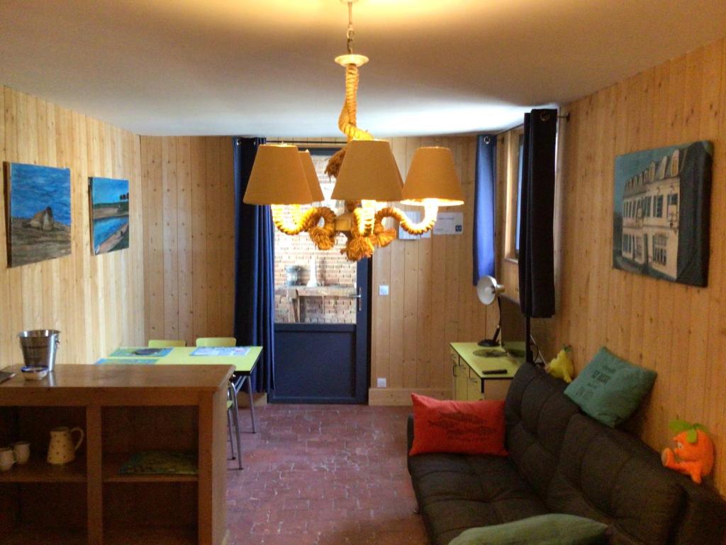 - un salon avec un canapé, une table et un lustre dans l'établissement La cabine le Courlis, au Tréport