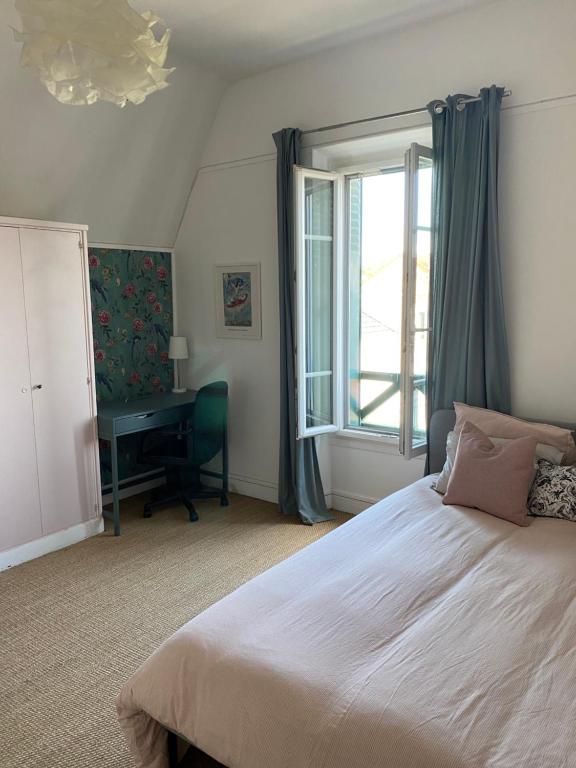 Schlafzimmer mit einem Bett, einem Schreibtisch und einem Fenster in der Unterkunft Maison de charme Jo Paris 2024 in Vaires-sur-Marne