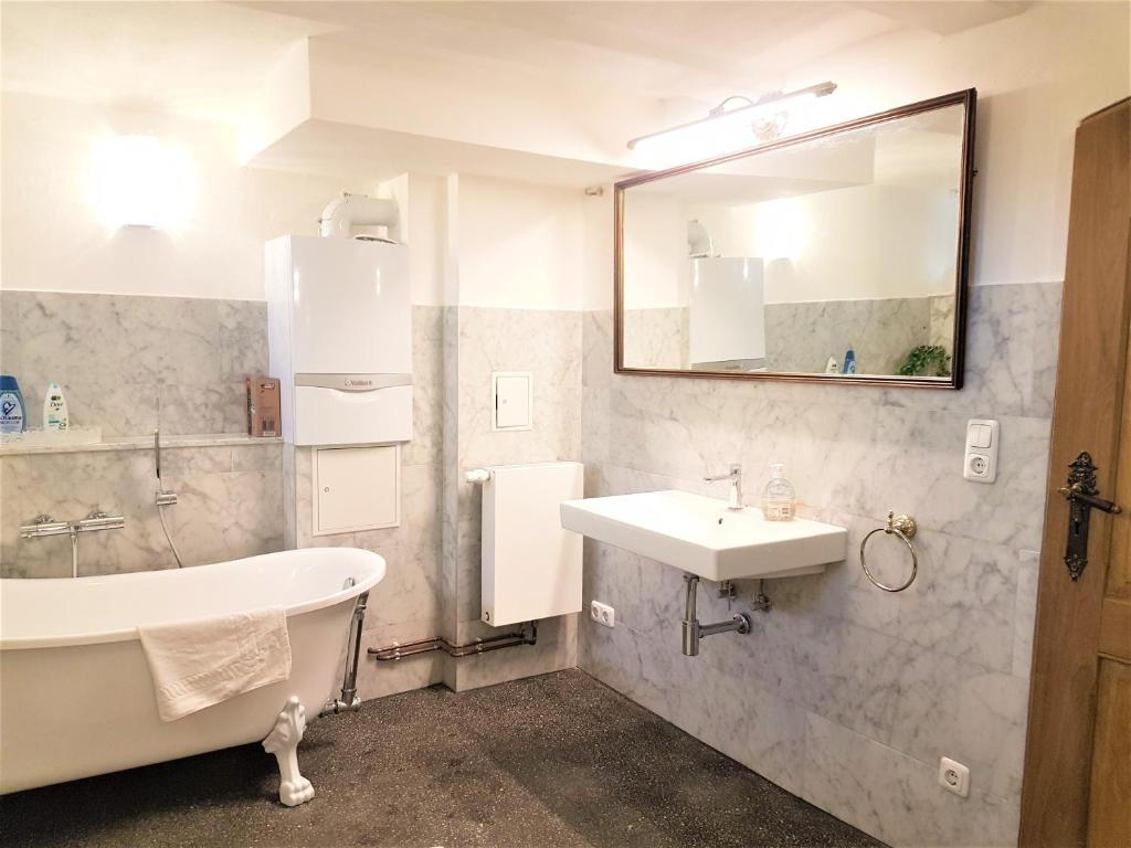 a bathroom with a tub and a sink and a bath tub at Deluxe Appartement bis 6 Personen Halbpension buchbar im Oberharz Unik Villa in Sankt Andreasberg