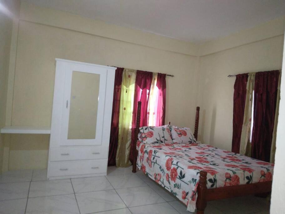 Schlafzimmer mit einem Bett, einer Kommode und einem Spiegel in der Unterkunft Ark Royal of the Caribbean in Arnos Vale