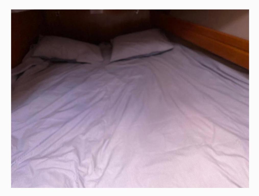 1 cama blanca grande con sábanas y almohadas blancas en Velero en club náutico valencia mar en Valencia