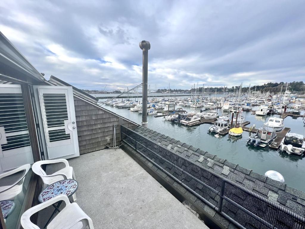 a balcony with two chairs and a marina with boats at Horizon Hideout C202 and 302 in Newport