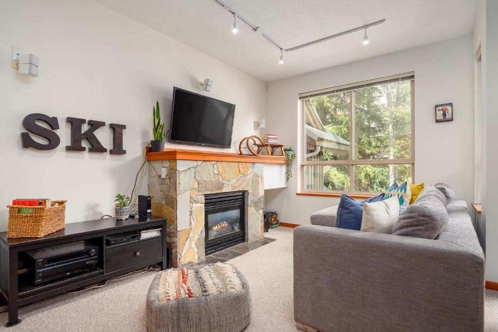 sala de estar con chimenea y TV en Bright Multi-Level Home, en Whistler