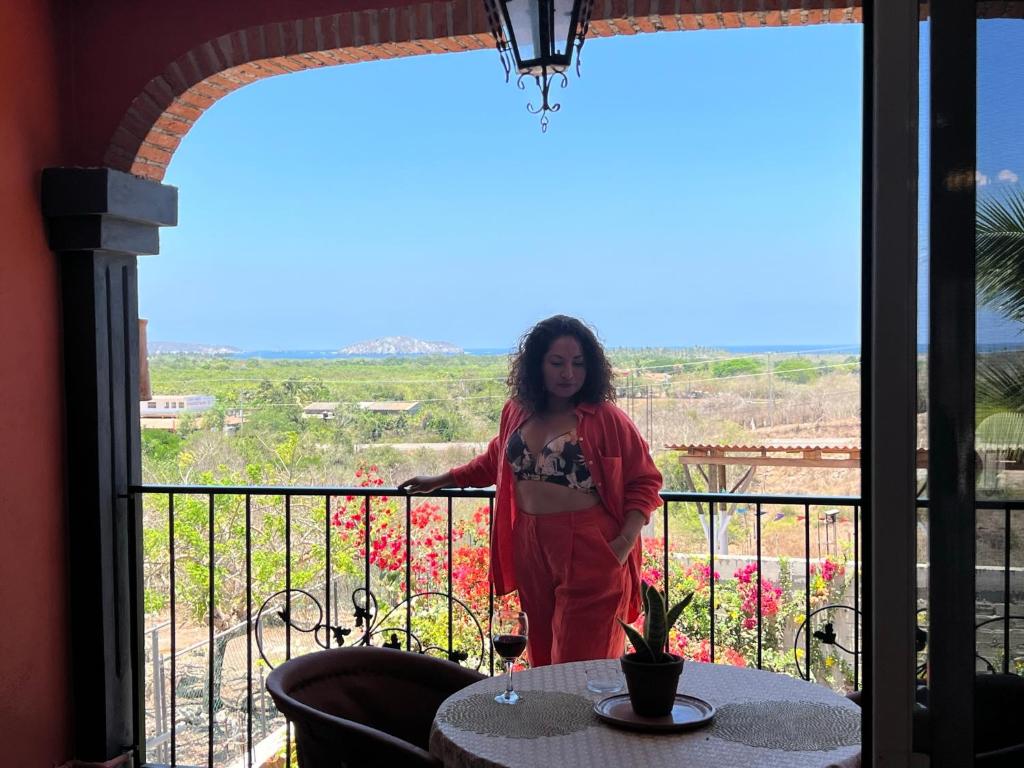 une femme debout sur un balcon avec vue dans l'établissement Casa Punta Perula VILLAS, à #N/A