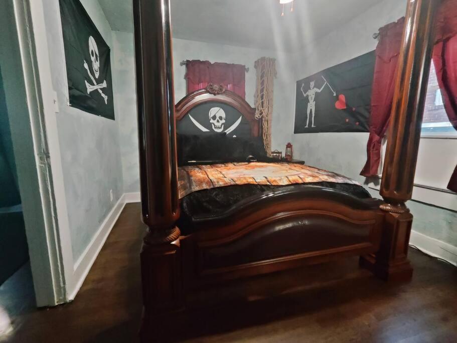 1 cama con marco de madera en una habitación en Pirate Seeking crew. Downtown Fort Smith, en Fort Smith