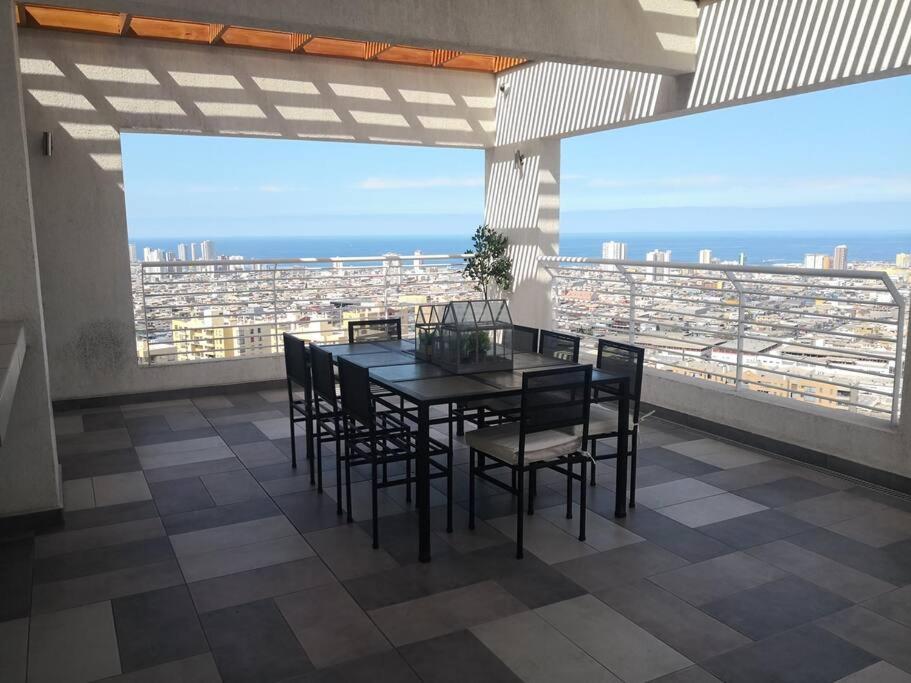 a dining room with a table and chairs on a balcony at Maravilloso Depto 3 habitaciones 1 baño - familiar Iquique in Iquique