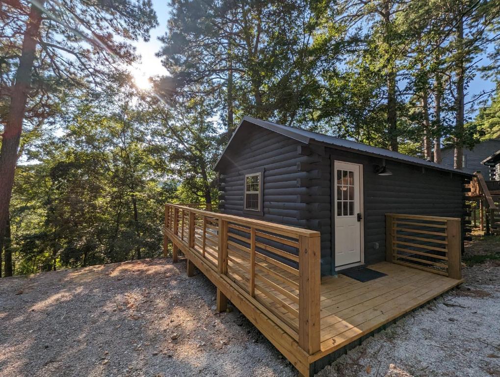 a cabin with a deck and a door at Log Cabin #2 with hot tub deck and sunset view at Loblolly Pines in Eureka Springs