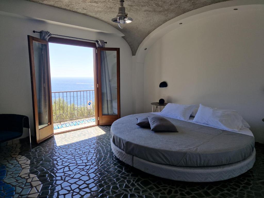 a bedroom with a large bed and a large window at HOLIDAY double in Praiano