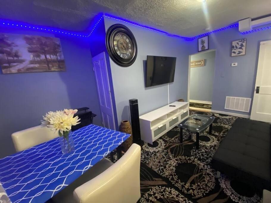 un salon bleu avec une table et une horloge dans l'établissement CHRIS LUXURY HOME, à Baltimore