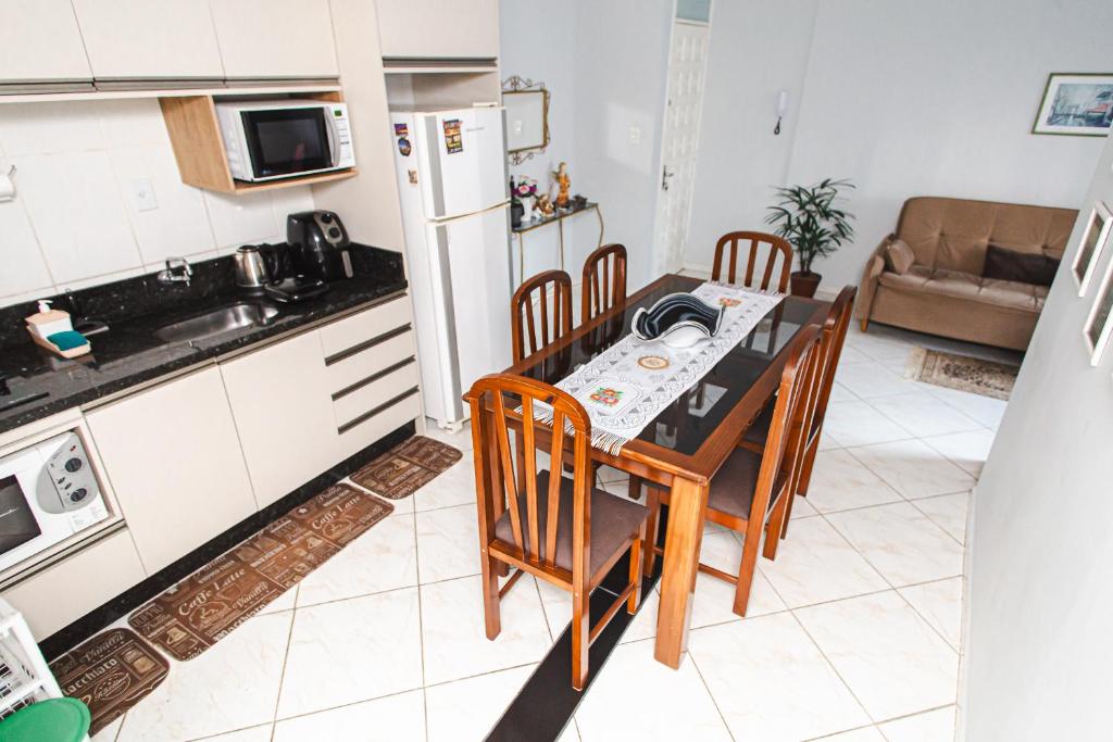 eine Küche mit einem Tisch und Stühlen sowie einem Kühlschrank in der Unterkunft Amplo e iluminado apto central para temporada in Balneário Camboriú