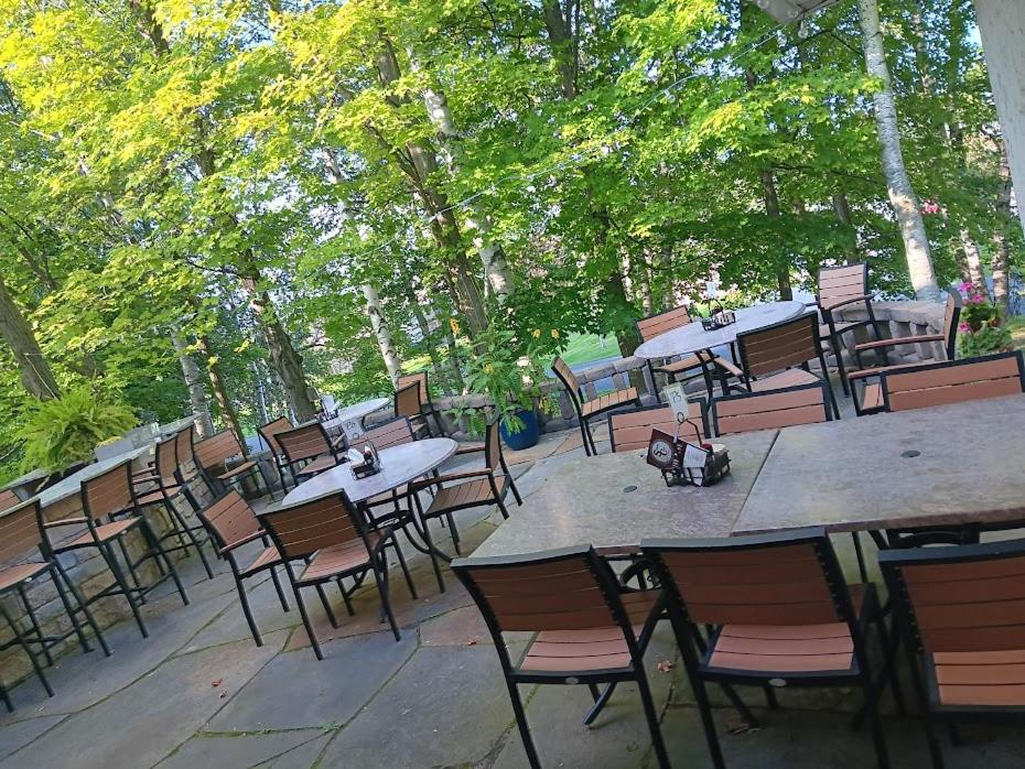 a group of tables and chairs with trees in the background at White Birch Inn in Sturgeon Bay