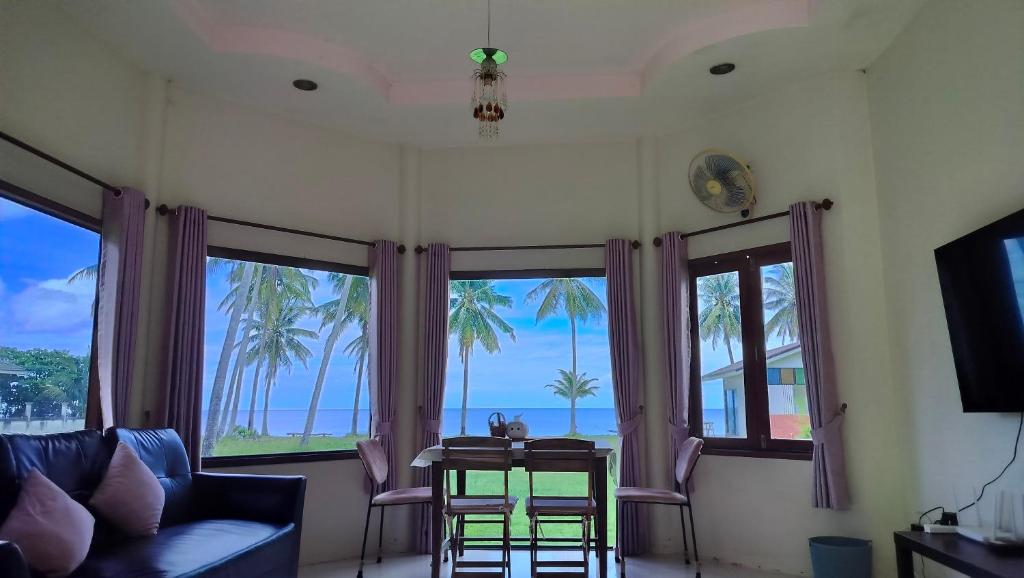 a living room with a view of the ocean at Baan Be Beach in Lang Suan