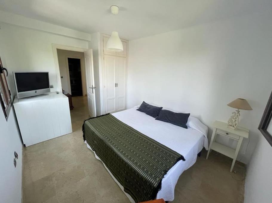 ein Schlafzimmer mit einem Bett und einem TV in der Unterkunft Atuaire Home Sevilla in Mairena del Aljarafe