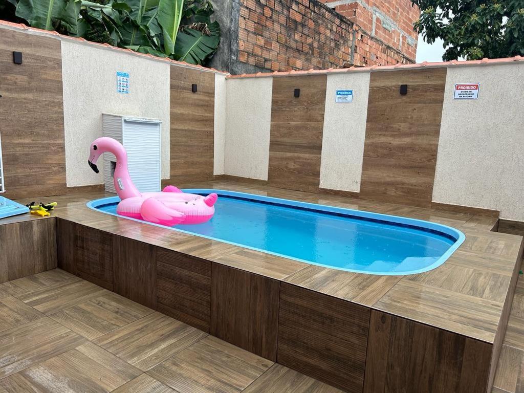 大伊瓜巴的住宿－Casa iguaba com área de lazer，木制甲板上的游泳池及其粉红色火烈鸟
