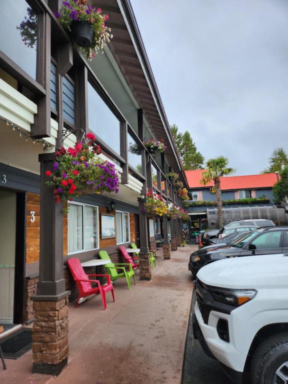 a street with cars parked in front of a building at Schooner Motel in Tofino