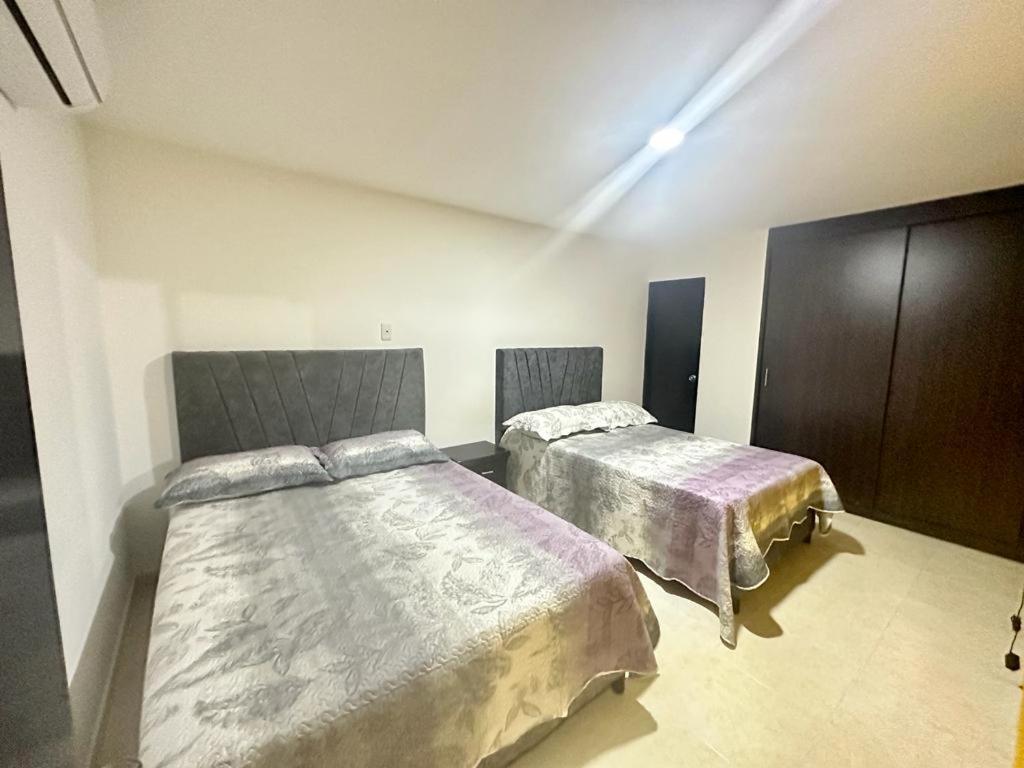 1 dormitorio con 2 camas en una habitación en HOTEL HOME UNICENTRO, en Villavicencio