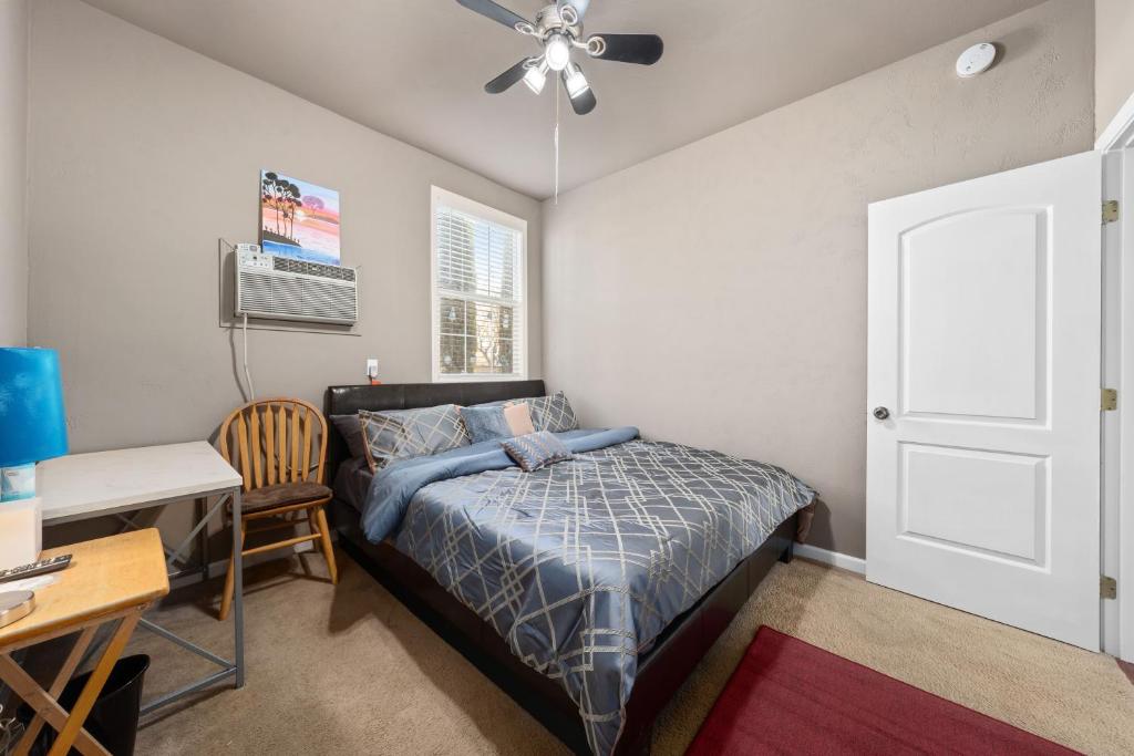 a bedroom with a bed and a desk and a ceiling fan at Cozy 1 bdr/1br near downtown in Sacramento